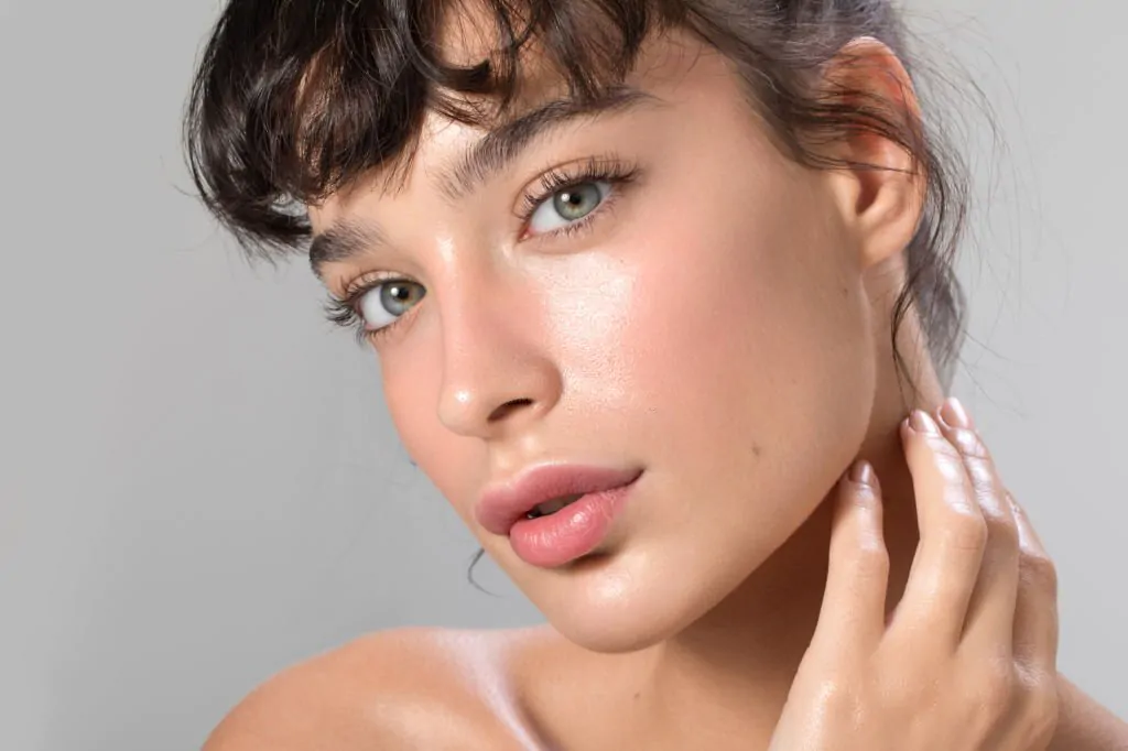 a women with her hand on her neck flaunting her face after facial